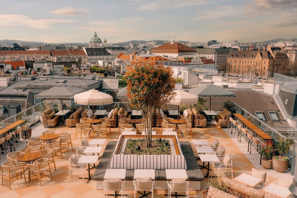 Terrasse mit einem Baum und vielen Stühlen und Tischen