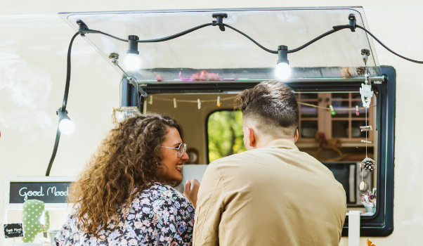 Zwei Personen die vor einem Foodtruck stehen