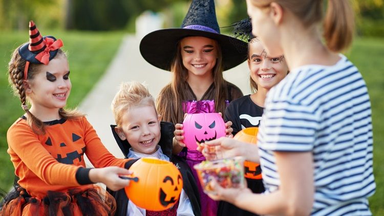 Halloween: Geschminkte Kinder erhalten Süßigkeiten
