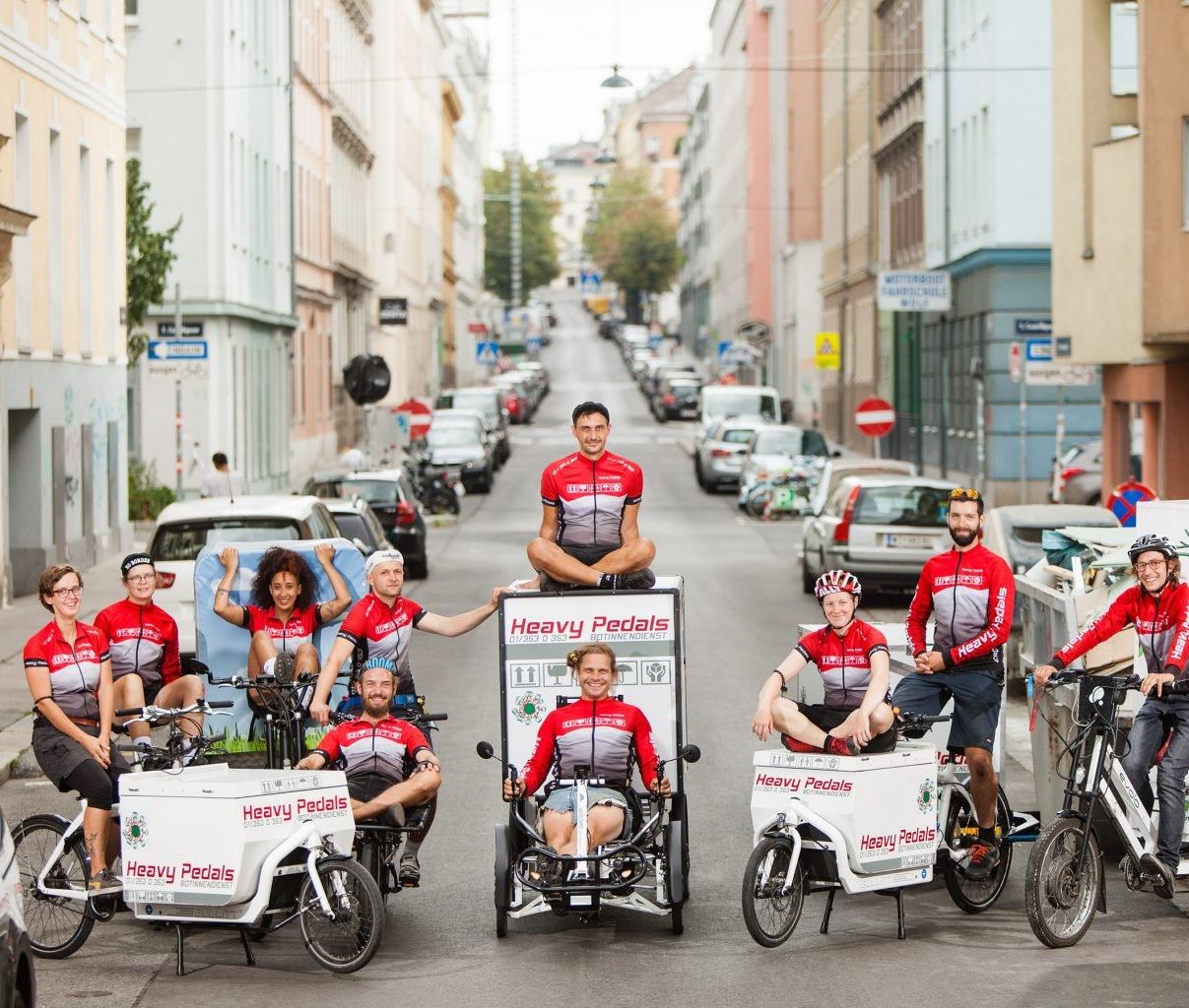 Eine Gruppe von Menschen auf Lastenfahrräder, die mitten auf der Straße posieren.