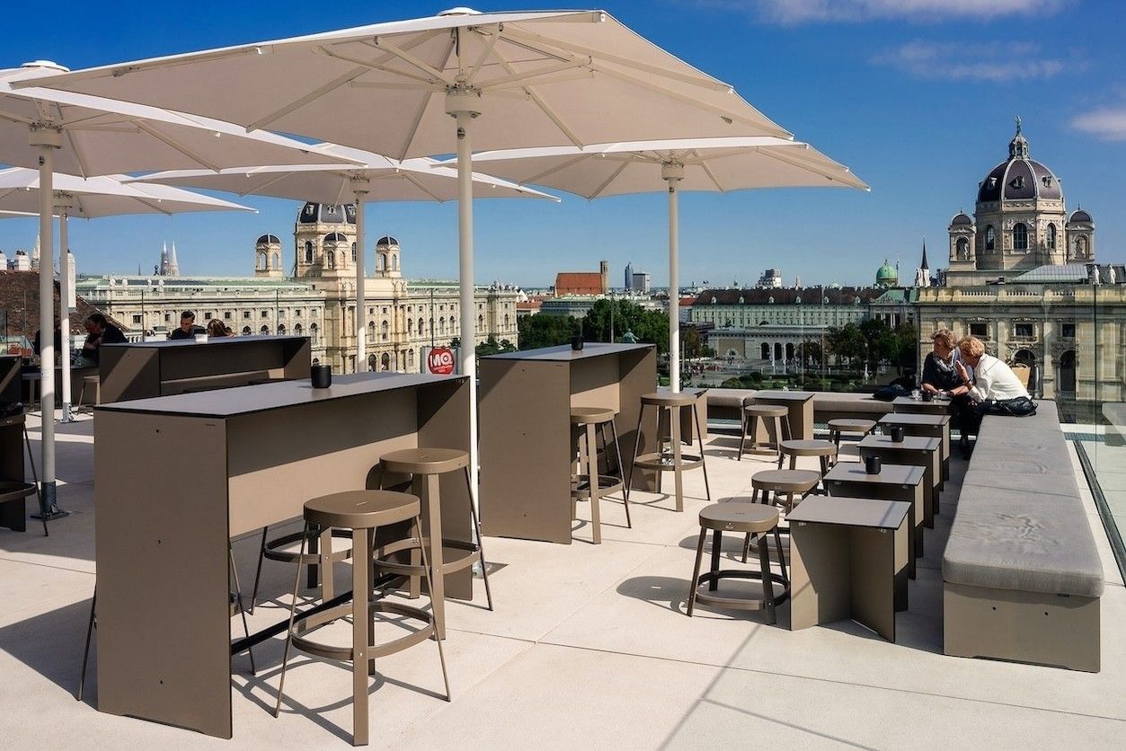 Rooftop Terrasse mit Schirmen und vielen Stühlen und Tischen