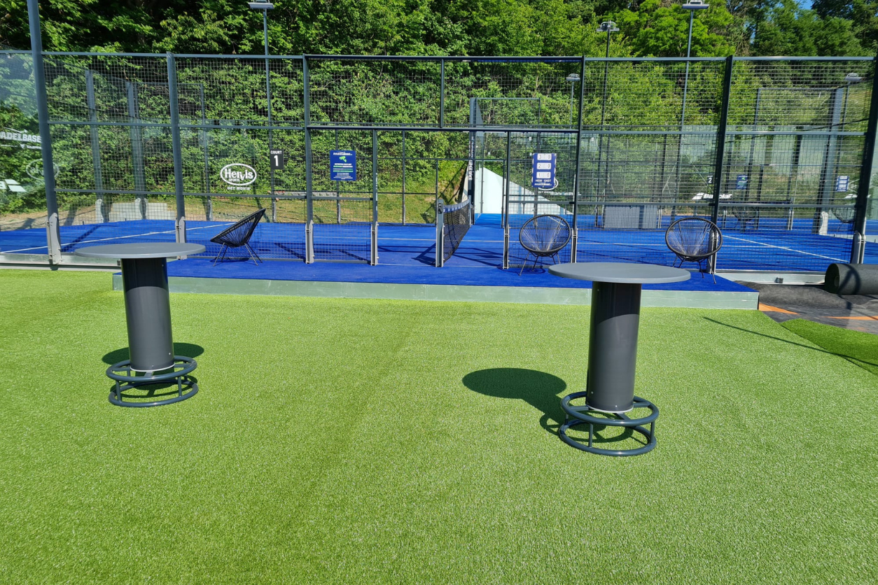 Padelcourt mit zwei Bartischen zum zuschauen. 