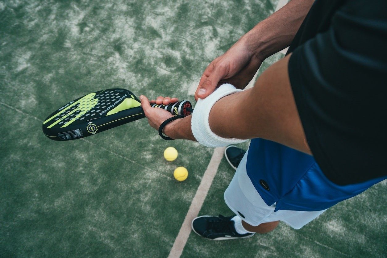 Person auf einem Padelcourt und einem Schläger in der Hand