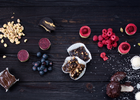 Süßigkeiten und Beeren auf einem dunklen Holztisch