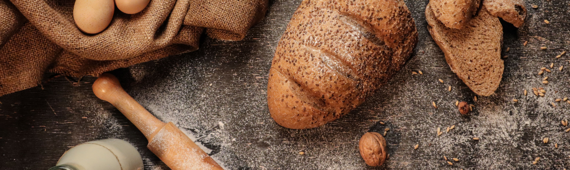 Sicht auf Brot und Weckerl auf einem Tisch mit einem Sack und einer Walnuss