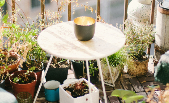 Foto: Am Balkon steht ein Tisch und viele unterschiedliche Pflanzen