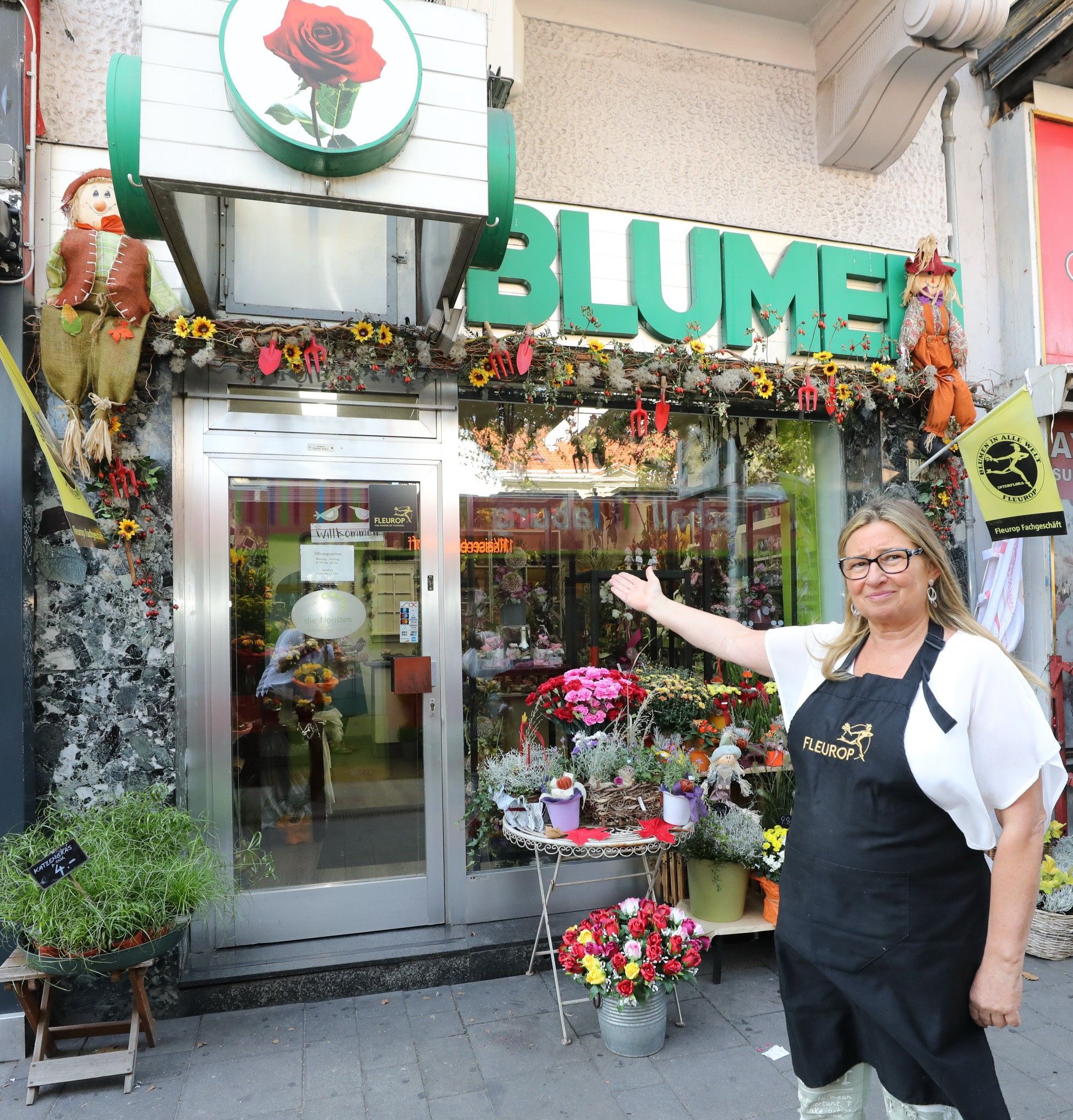 Eingangsbereich von Blumen Wagner, geschmückt mit bunten Blumen und herbstlicher Dekoration