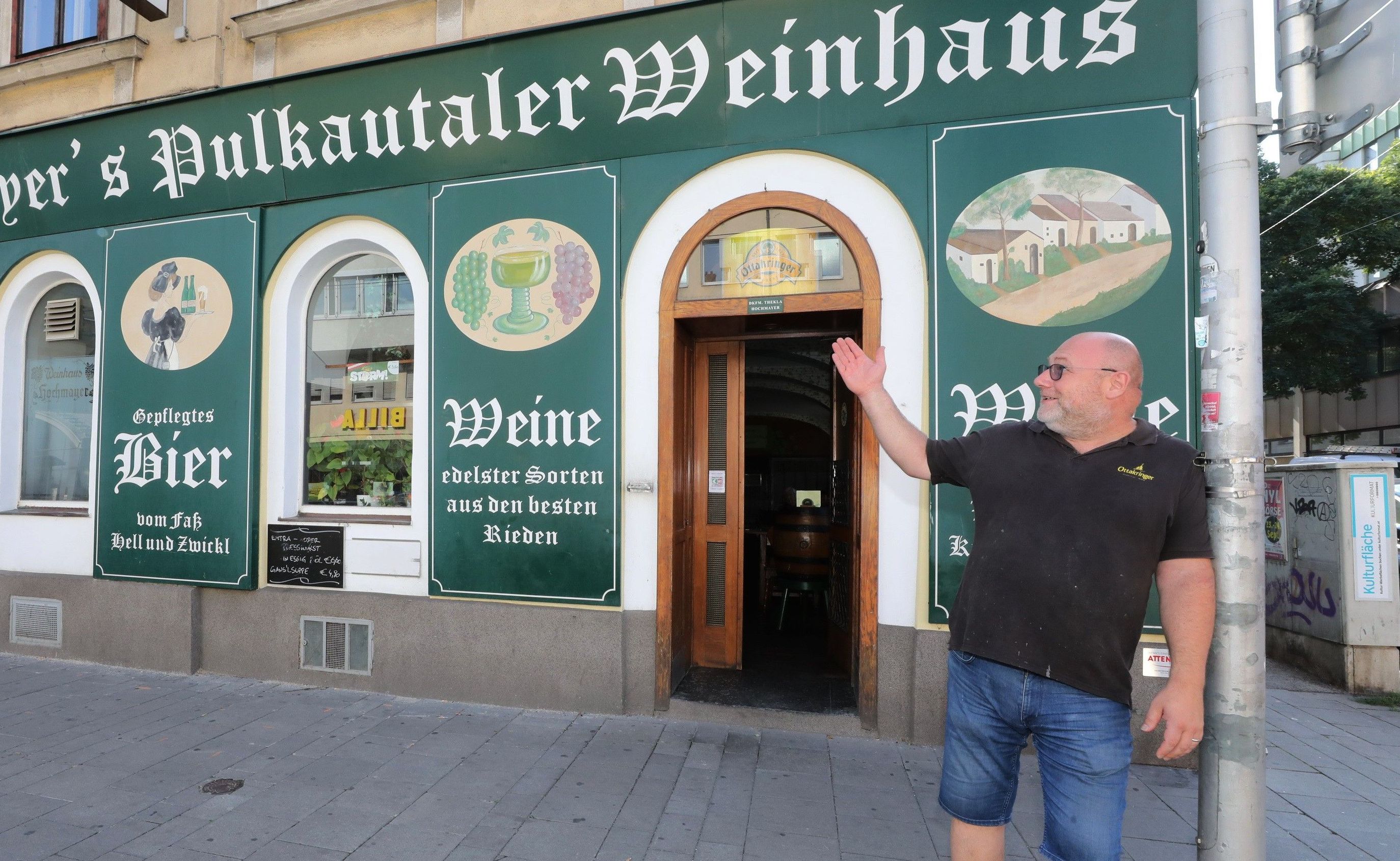 Außenbereich vor Hochmayer's Pulkautaler Weinhaus und Mann, der auf das Lokal und den Eingang zeit