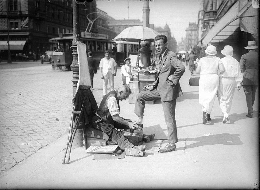 Foto: Foto der Kärntner Straße früher, auf der sich ein Mann die Schuhe putzen lässt.