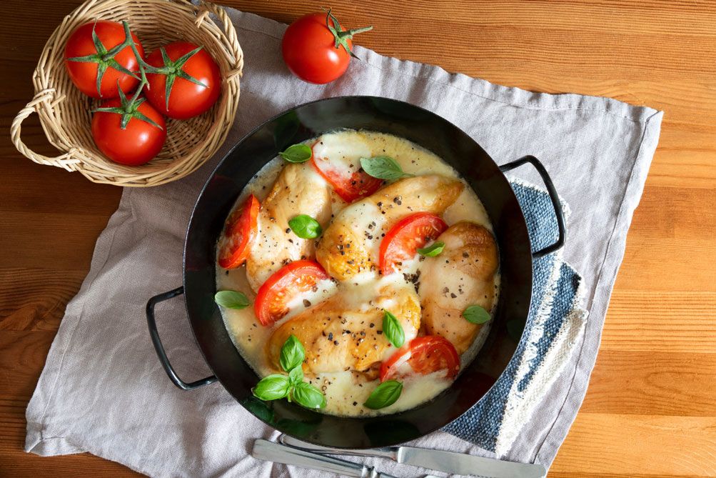 Gericht mit Hühnerbrust, Tomate, Käse und Basilikum