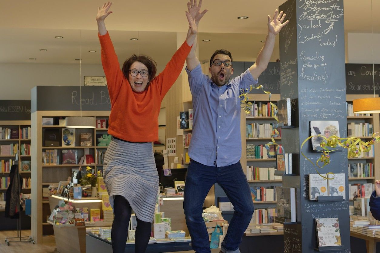 Buchhandlung mit Eigentümern die gerade in die Luft springen