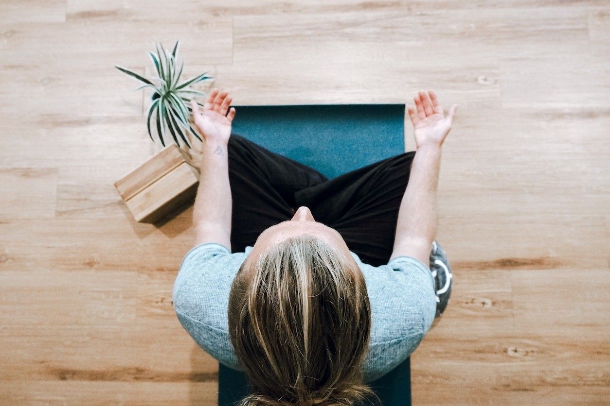 Eine Frau von oben im Meditationssitz